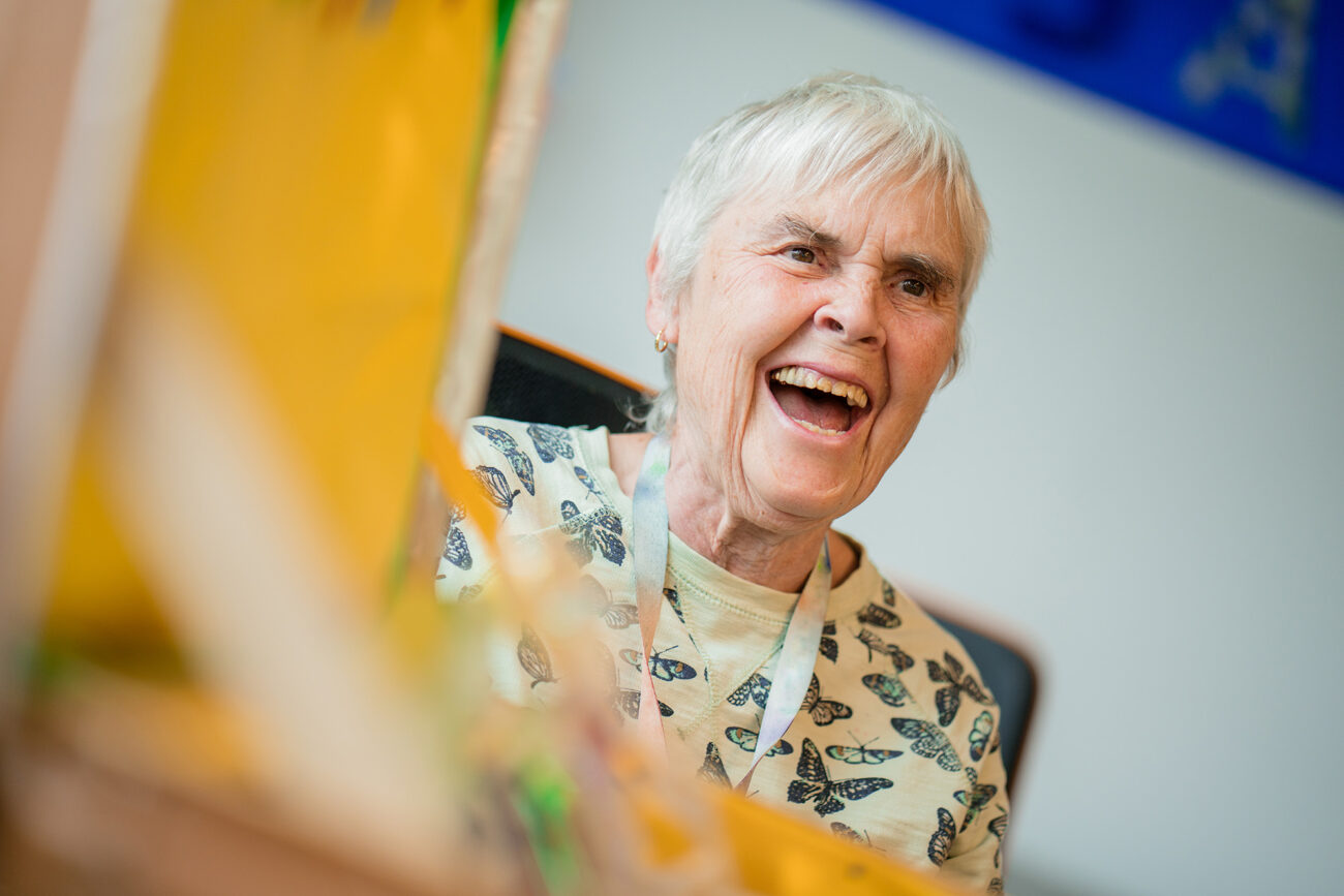 Eine Mitarbeiterin des Ateliers hat Freude und lacht
