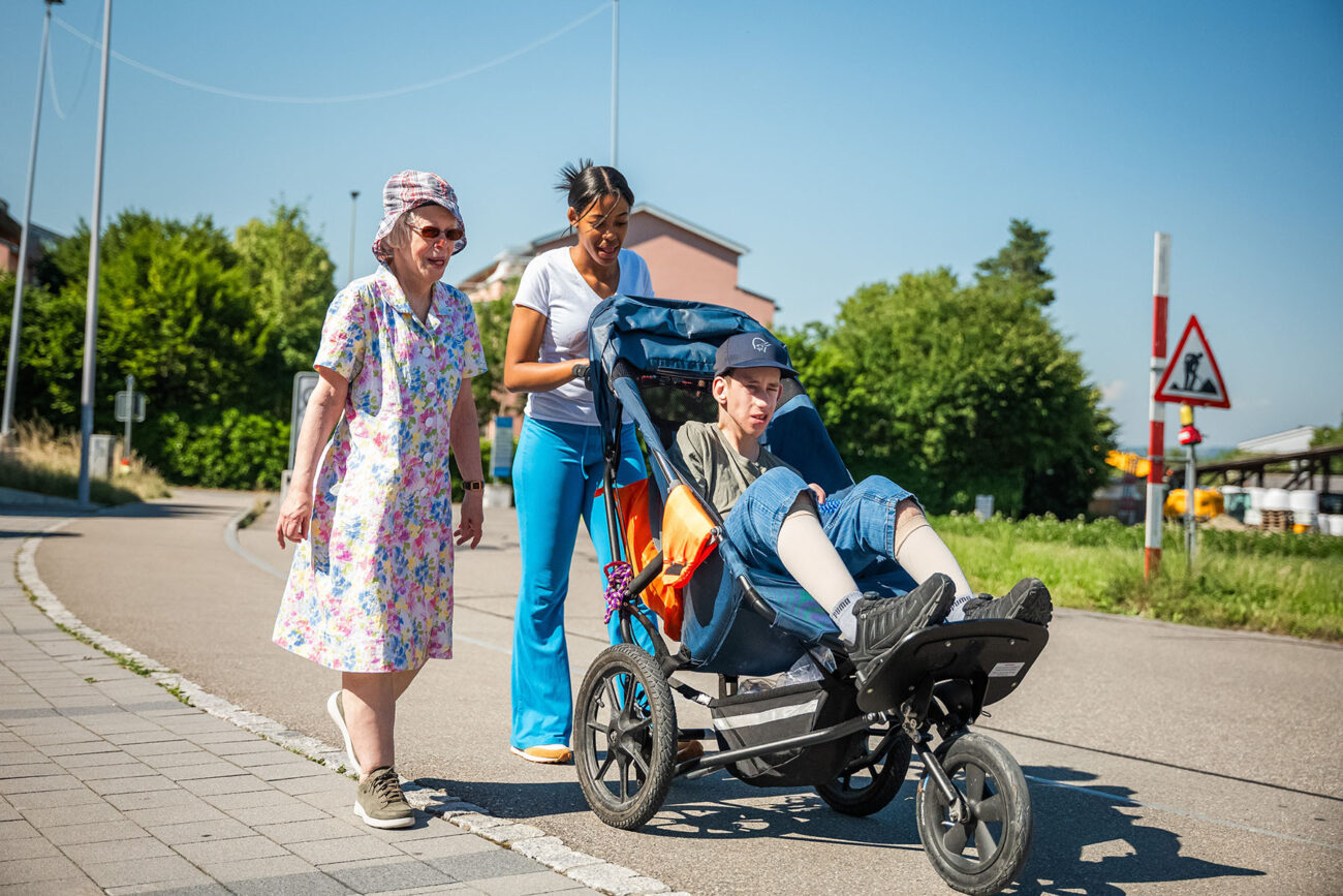 Drei Personen machen einen Spaziergang in der Sonne