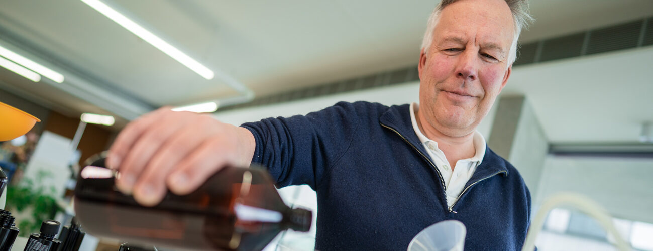 Ein Mitarbeiter füllt etwas in eine Flasche ab