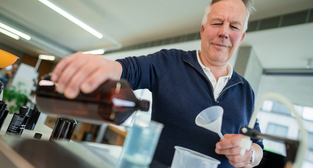 Ein Mitarbeiter der Produktion füllt etwas in Flaschen ab