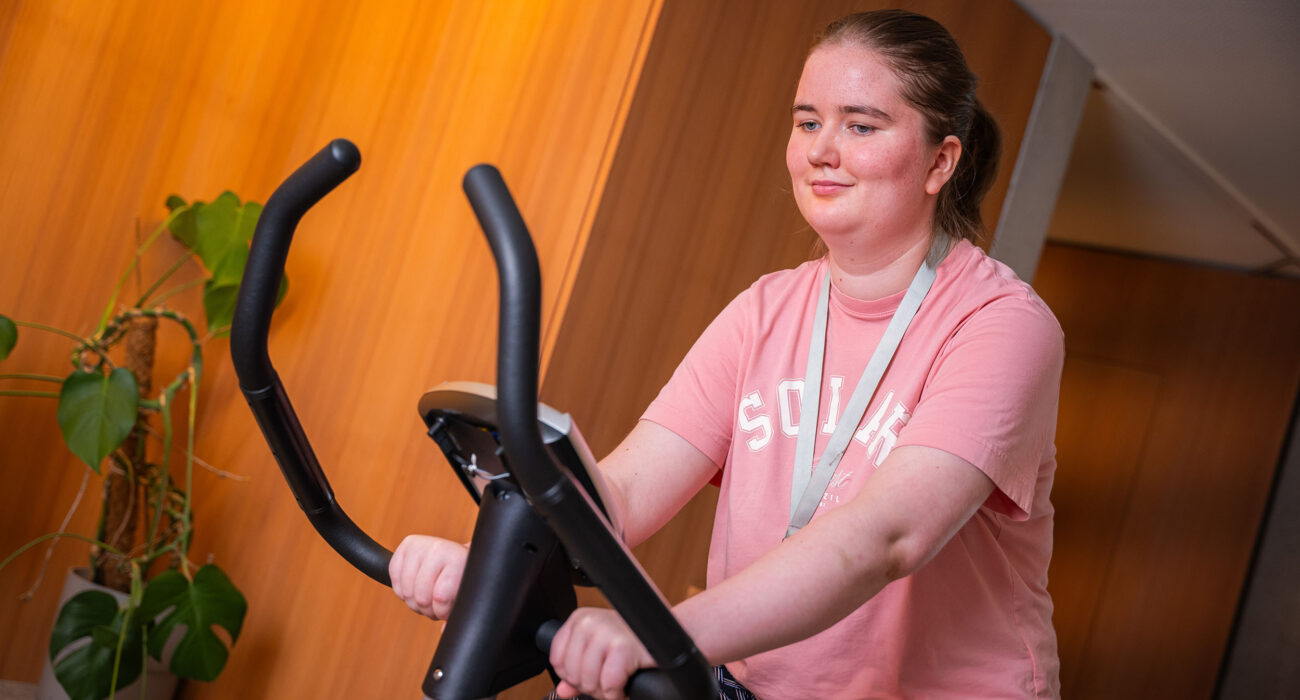 Eine Bewohnerin fährt auf dem Hometrainer