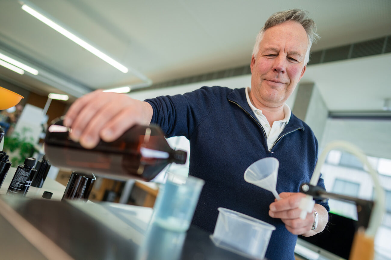 Ein Mitarbeiter der Produktion füllt etwas in Flaschen ab