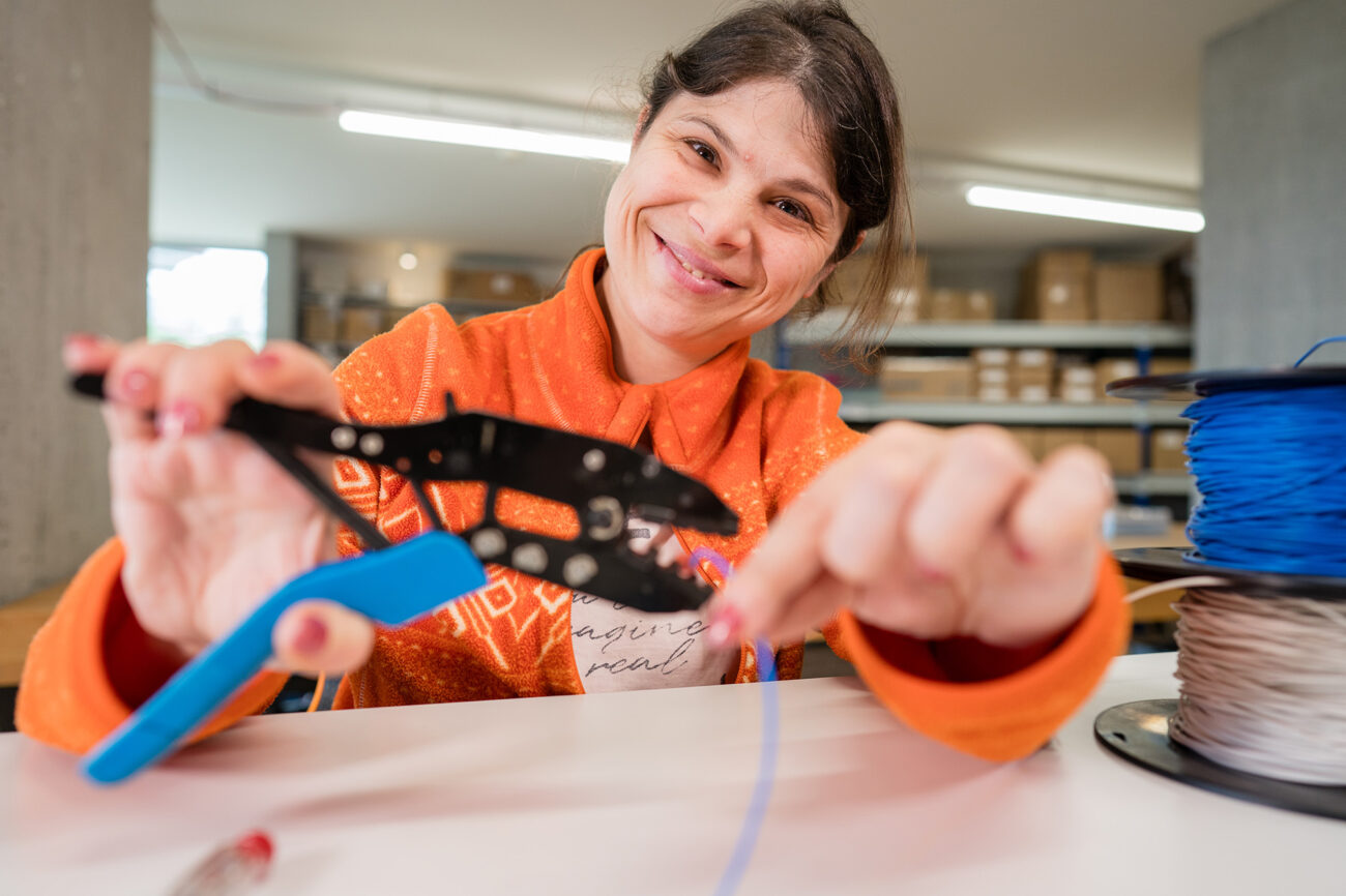 Eine Mitarbeiterin der Produktion zeigt wie man lötet