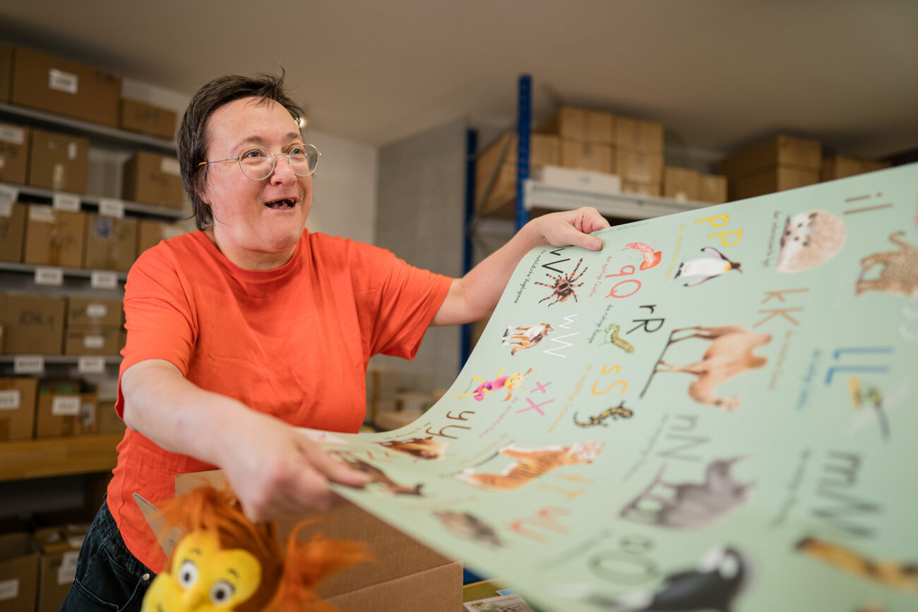 Eine Mitarbeiterin faltet ein Plakat zum Einpacken
