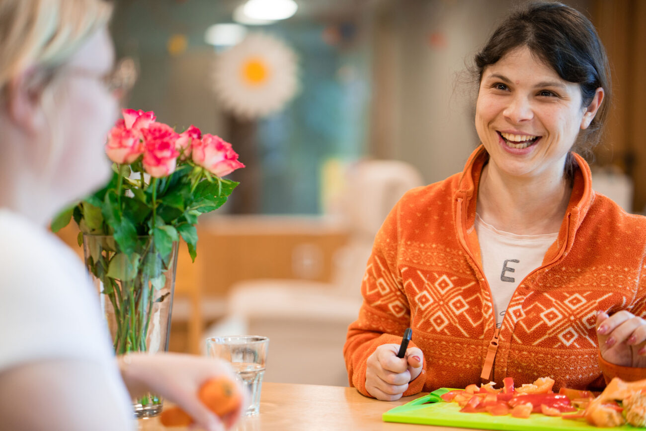 Eine junge Frau schneidet Gemüse für das Essen